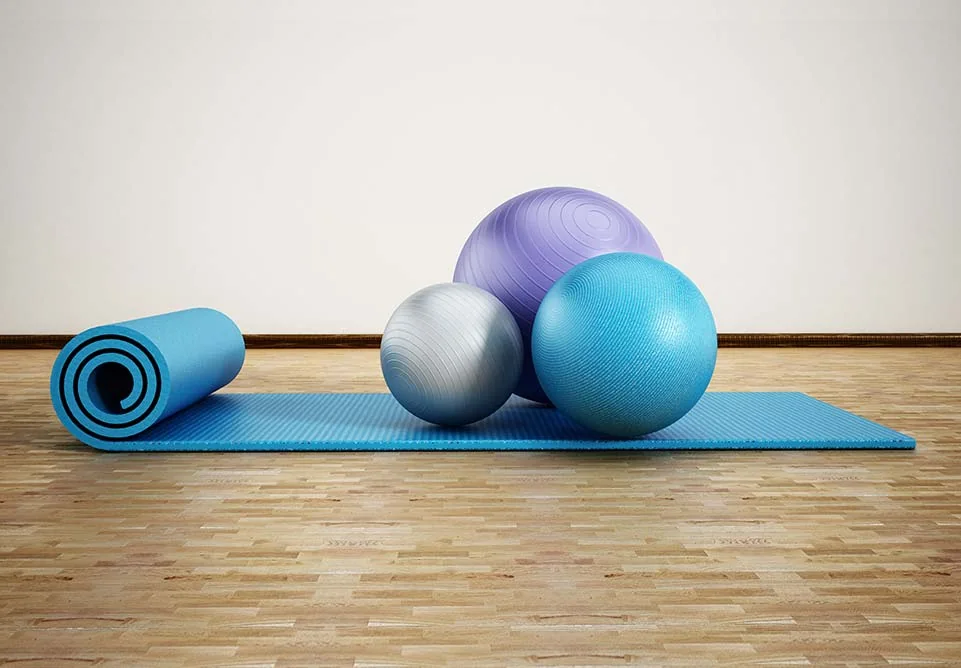 Exercise mat and balls set out for a Pilates session
