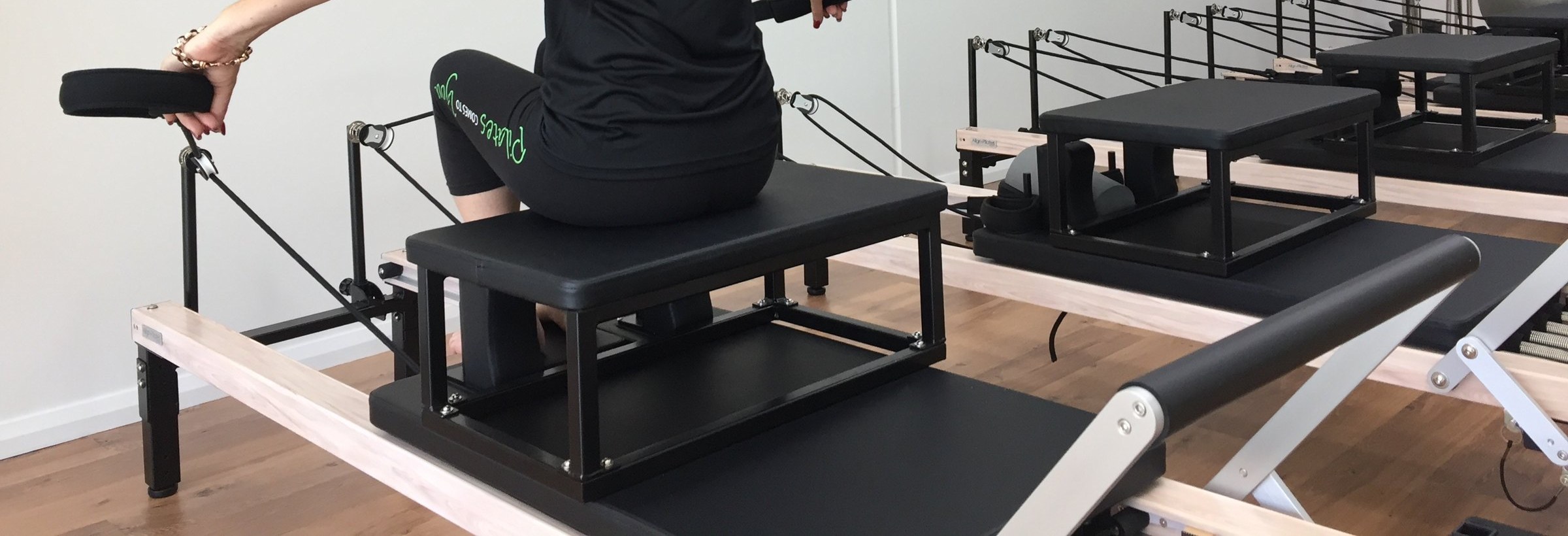 Seated arm work with straps on the Pilates reformer at Pilates Comes To You